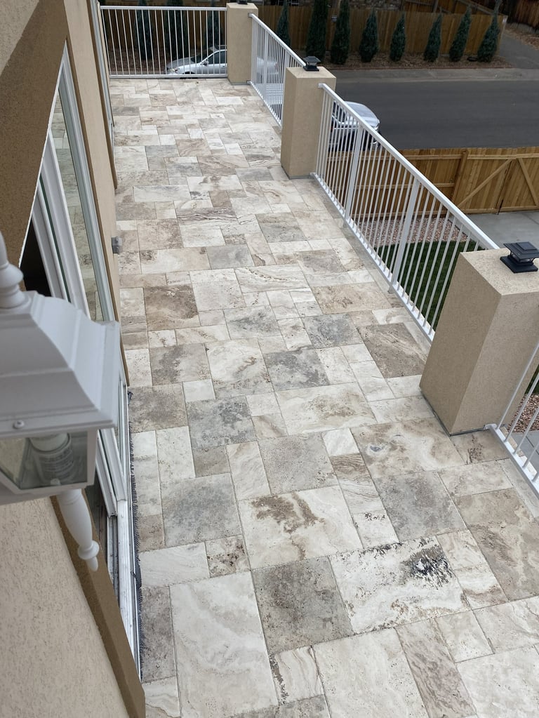 Long tiled corridor with white metal gates, industrial/commercial indoor space with alternating stone tile pattern