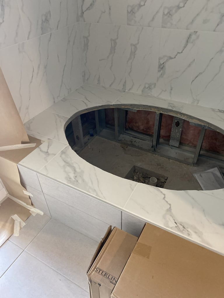Circular opening in marble countertop with curved window frame and renovated bathroom interior visible below